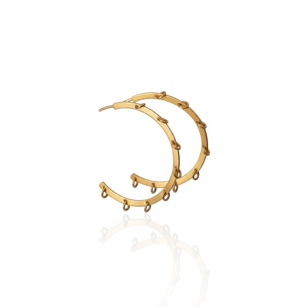 A pair of gold-toned hoop earrings with small dangling bead-like accents, shown on a clean white background with a soft reflection below.