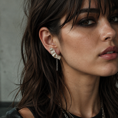 Athena wearing Aether Rocker Wing Earrings, silver wing earrings with chain drop and dark editorial styling