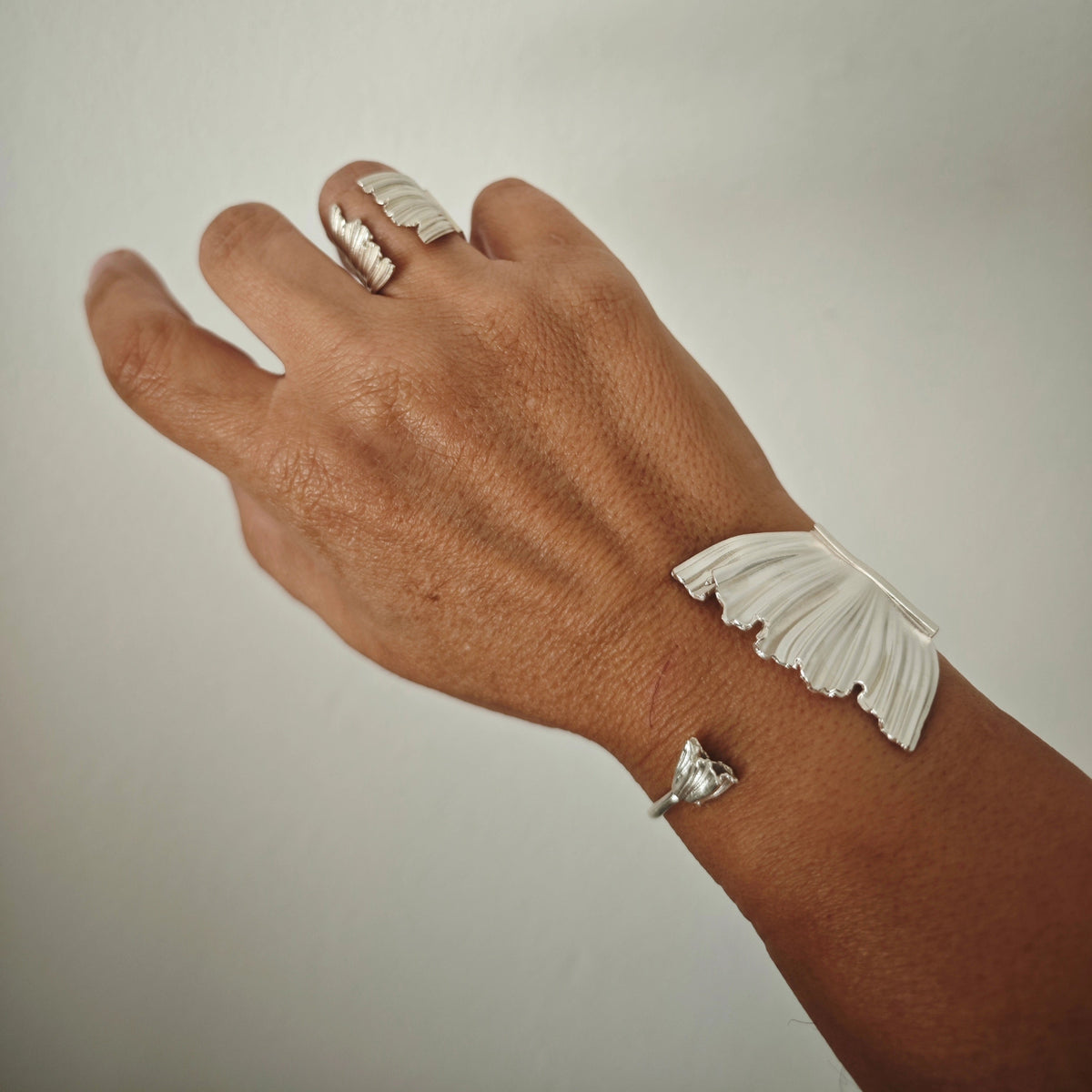 Peplos Aura Cuff Bracelet worn on hand with matching Peplos ring in silver
