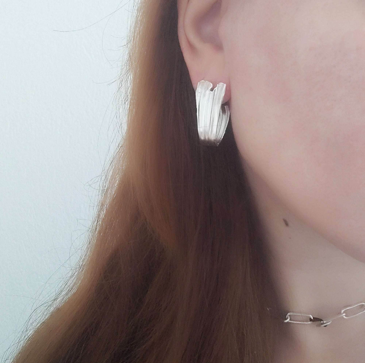 Side view of model with Swan Hoops – folds inspired by Greek drapery.