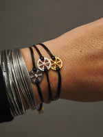 Three Wheel of Fortune silver cord bracelets in silver, oxidized and gold-plated finishes, styled with sculptural silver cuffs.
