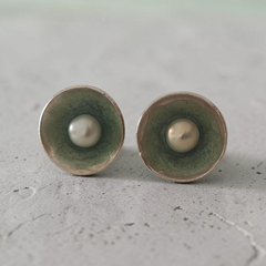Editorial close-up of a model wearing handmade Nerida pearl stud earrings by Athenart Jewelry