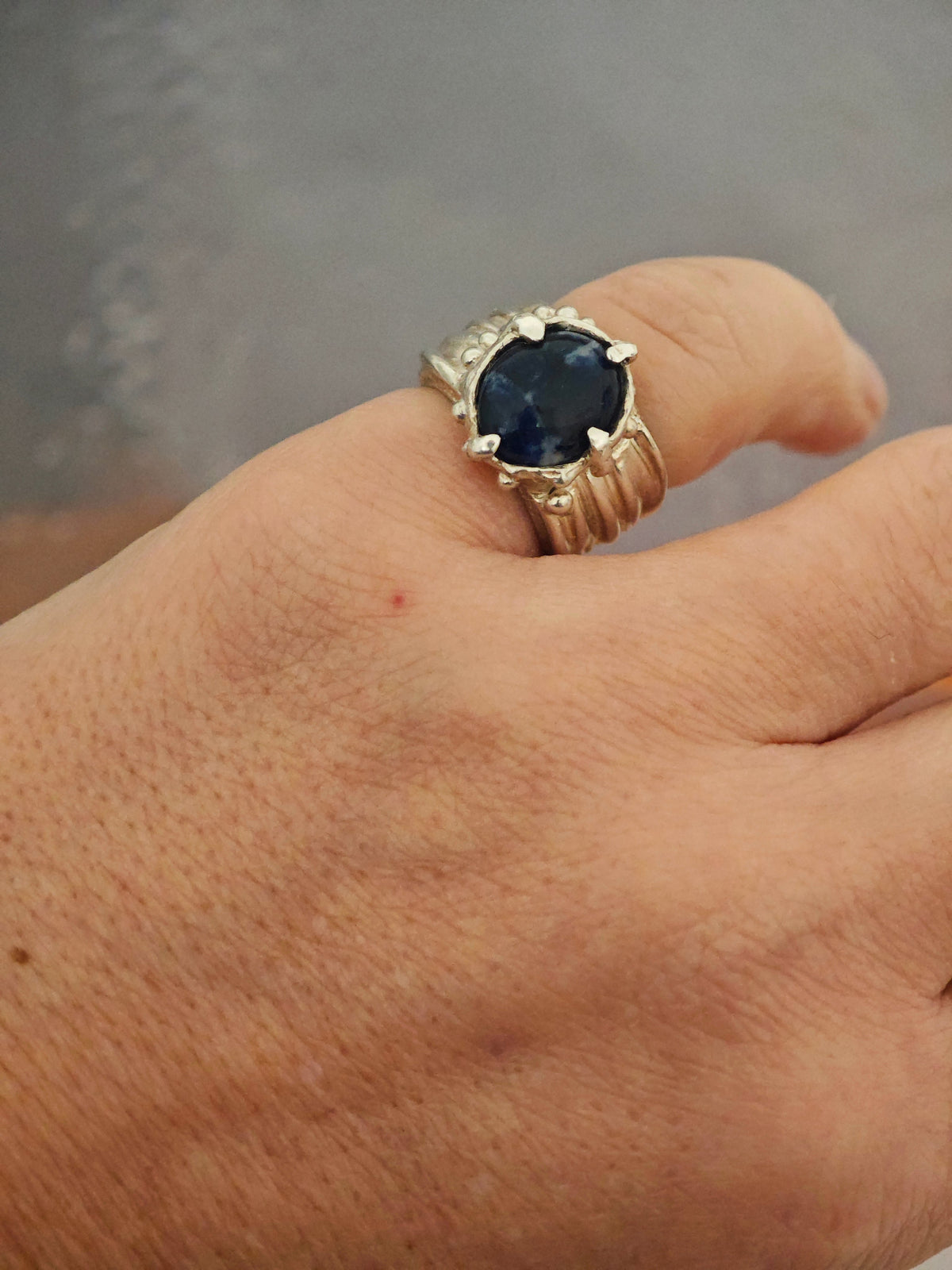 One-of-a-kind sodalite ring in sterling silver worn on hand, adjustable size 50–52