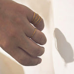Delicate handmade gold rings worn stacked on the finger