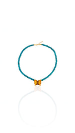 Turquoise beaded necklace with a gold clasp on a white background