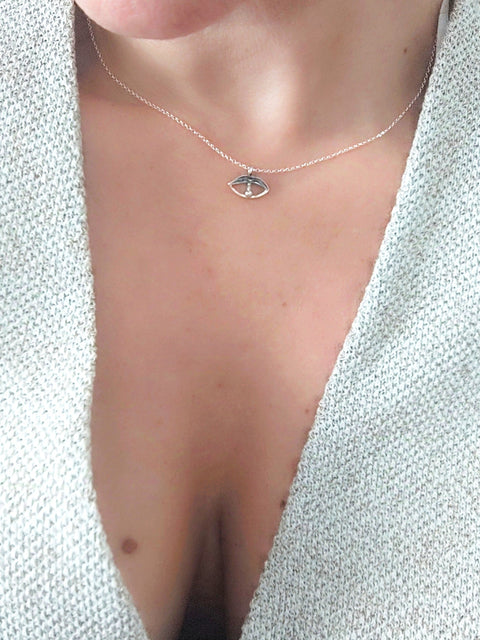 Necklace with a small pendant worn by a person against a light background