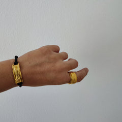 Peplos drapé bar cord bracelet worn on wrist, adjustable black cord