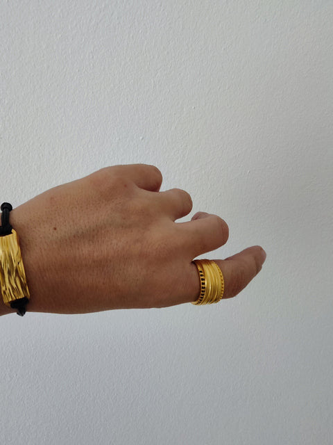 Peplos drapé bar cord bracelet worn on wrist, adjustable black cord